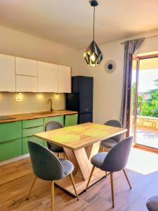 a kitchen with a wooden table and chairs in a room at Apartment Park in Rabac