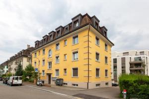 a yellow building on the side of a street at Eagle Suite Charmante Dachgeschosswohnung mit Design & Ausblick in Zurich