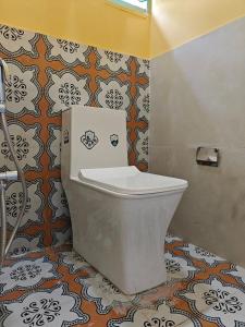 a bathroom with a white toilet in a room at Beachside in Anjuna