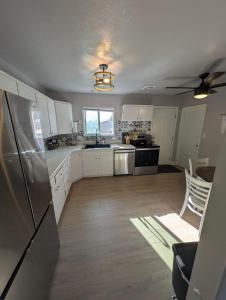 布里格姆城Cozy Mountain Home的配有白色橱柜和不锈钢冰箱的厨房 更多14张照片