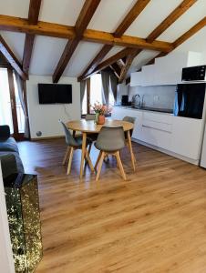 Appartamento Vittoria في كليس: مطبخ وغرفة طعام مع طاولة وكراسي خشبية +12 صورة