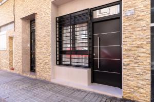 a black garage door on a brick building at Loft moderno recién reformado con patio en el centro de Elche in Elche