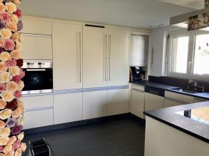 a kitchen with white cabinets and a stove top oven at Goldiger Berg - Pilatusweg 6 in Affoltern