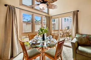 a dining room with a table and chairs and a couch at Kihei Sands B2 in Kihei