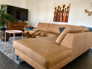 a living room with a brown couch and a table at Goldiger Berg - Pilatusweg 6 in Affoltern