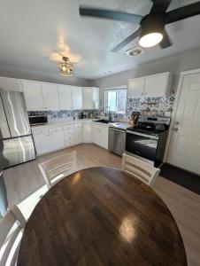 布里格姆城Cozy Mountain Home的配有木桌和白色橱柜的厨房