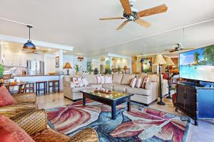 a living room with a couch and a tv at Hololani A402 in Kahana +32 photos