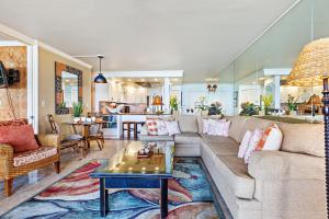 a living room with a couch and a table at Hololani A402 in Kahana