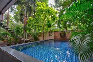 Luxury 3BHK Villa With Private Pool in Candolim في Nerul: مسبح في حديقة فيها نخيل