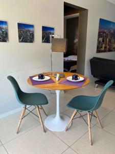 una mesa y dos sillas con platos de comida. en LK Santo Antônio 1, en Belo Horizonte