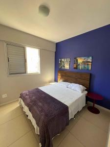 Un dormitorio con una cama grande con una pared azul. en LK Santo Antônio 1, en Belo Horizonte