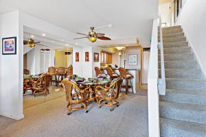 Kahana Villa E701 في Kapalua-West Maui Airport: غرفة طعام وغرفة معيشة مع طاولة وكراسي