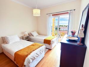 una camera da letto con due letti, un tavolo e una finestra di Balaia Maggs House Pool & Ocean view by BeCherish a Branqueira Altre 34 foto