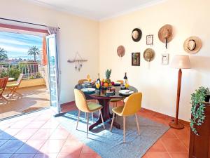 una sala da pranzo con tavolo e sedie e un balcone di Balaia Maggs House Pool & Ocean view by BeCherish a Branqueira