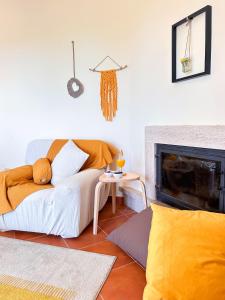 un soggiorno con divano e camino di Balaia Maggs House Pool & Ocean view by BeCherish a Branqueira