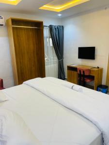 Un dormitorio con una cama y un escritorio con televisión. en Nucfam Hotel Ojodu, en Eggan 17 fotos más