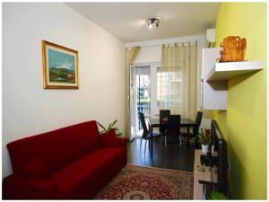 a living room with a red couch and a dining room at Studiohouserome in Rome