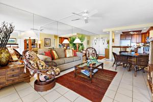 a living room with a couch and a table at Hololani A203 in Kahana