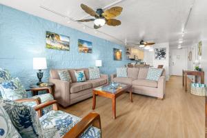 a living room with two couches and a table at Kanai A Nalu 202 in Wailuku