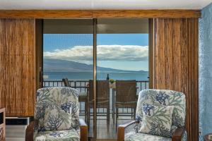 a room with two chairs and a view of the ocean at Kanai A Nalu 202 in Wailuku