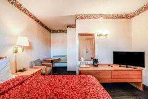 a hotel room with a bed and a flat screen tv at Ozark Junction Inn in Mountain View