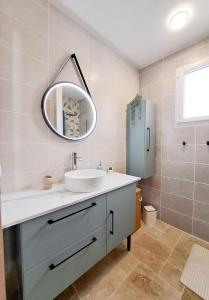 a bathroom with a sink and a mirror and a refrigerator at Les Sardines in Royan +19 photos