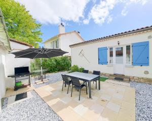 a patio with a table and chairs and an umbrella at Les Sardines in Royan