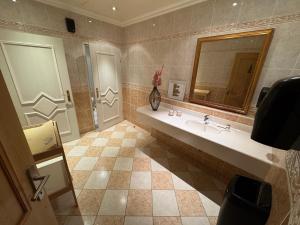 un baño con lavabo y espejo en Self-Check-in Hotel VinoQ Mistelbach, en Mistelbach