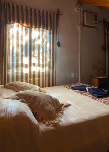 a bedroom with a large white bed with a window at Arboleda in Jardín América +10 photos