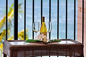 a bottle of wine and flowers on a table at Kahana Reef 408 in Kahana