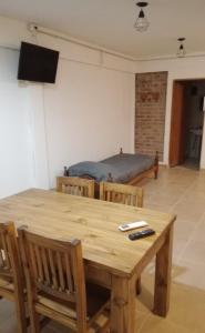 RM RinconMoreno في ريو كولورادو: غرفة مع طاولة خشبية مع كراسي وسرير