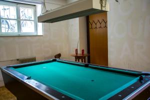 a pool table in a living room with at C - Punkt Hostel in Ljubljana