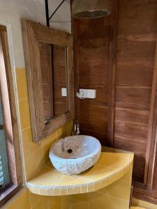 a bathroom with a stone sink on a counter at Green vanilla Suite 1 in Silebeng +11 photos