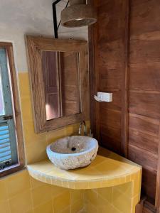 a bathroom with a stone sink on a shelf at Green vanilla Suite 1 in Silebeng
