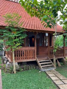 a home with a wooden porch and a red roof at Green vanilla Suite 1 in Silebeng