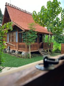 a model of a wooden house with a tree at Green vanilla Suite 1 in Silebeng