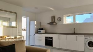 a kitchen with white cabinets and a refrigerator at El Timón in La Santa