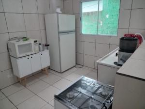 een keuken met een koelkast en een magnetron bij Casa independente e aconchegante in Poços de Caldas