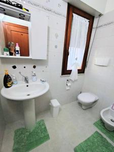 "Da Carla e Sandro" في كوارتوتشو: حمام أبيض مع حوض ومرحاض