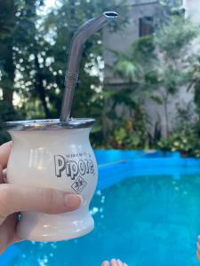 una persona che tiene una bevanda in una tazza con una cannuccia di Arboleda a Jardín América