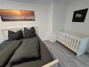 a bedroom with a large bed and a crib at FERIENWOHNUNG 75m2 APARTMENT in ZITTAUER STADTZENTRUM INNENSTADT INNENRING TOP LAGE - WOHNEN AUF ZEIT IN ZITTAU - 3 RAUM WOHNUNG in Zittau
