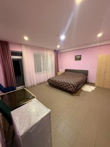 a bedroom with a bed and pink walls at Bernotiškių Hotel & Dining 