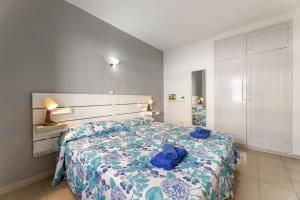 une chambre avec un lit recouvert d'une couette bleue dans l'établissement Apartamentos Luz Y Mar, à Puerto del Carmen