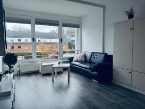a living room with a couch and a table and windows at Sealine Laboe in Laboe