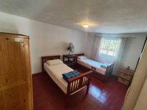 a bedroom with two beds and a window at Rincón del Rio San Antonio in San Antonio de Arredondo