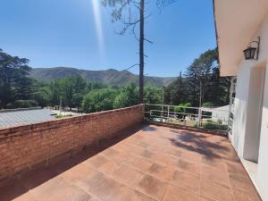 a balcony with a brick wall and mountains in the background at Rincón del Rio San Antonio in San Antonio de Arredondo