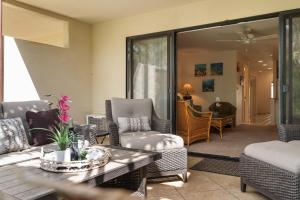 a living room with wicker chairs and a table at Maui Kamaole K104 in Wailea