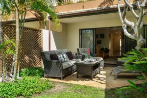 a patio with two chairs and a table at Maui Kamaole K104 in Wailea