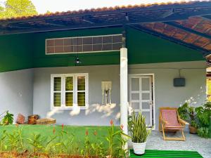 a green and white house with a patio at Massbungalow in Tindummal +9 photos