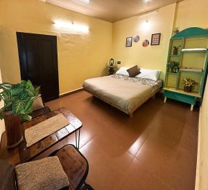 a bedroom with a bed and a couch and a chair at Massbungalow in Tindummal